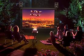 Family watching a movie in backyard